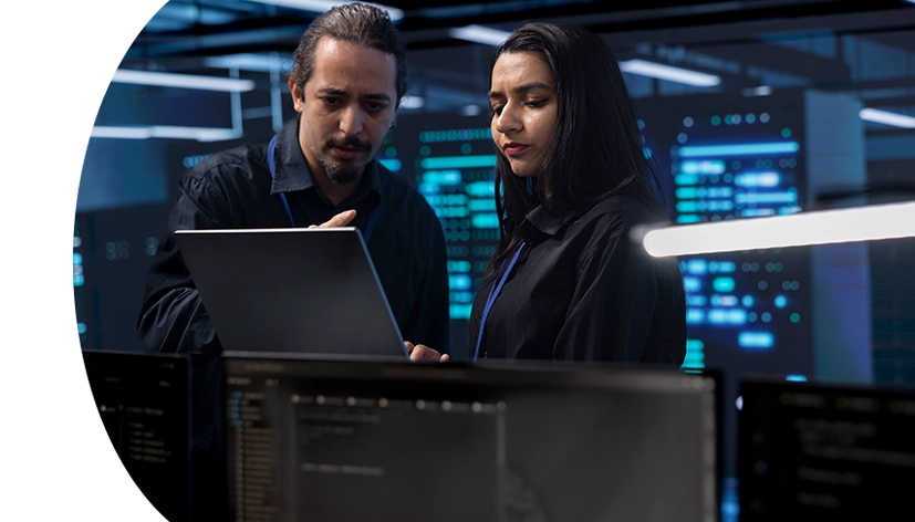 Coworkers in data center doing routine disk checks using laptop and tablet