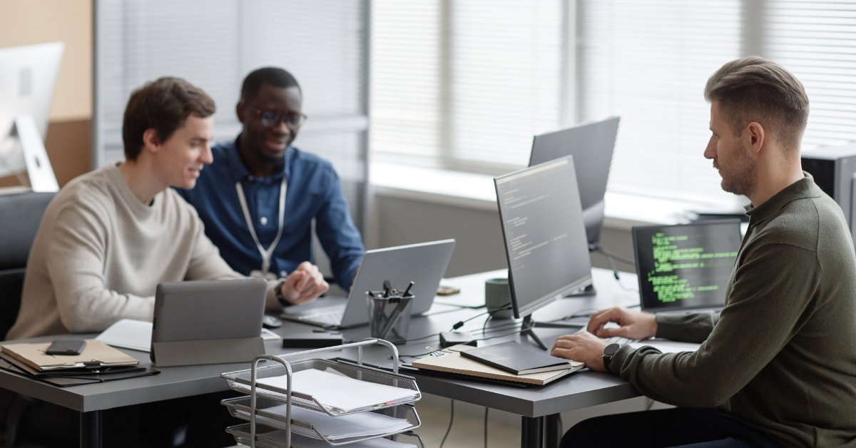 people working at desk on laptop