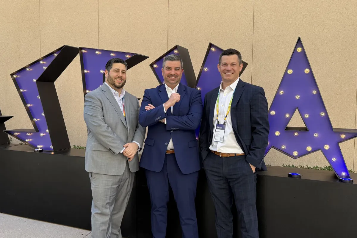 SecureWon leadership team standing in front of Kaseya sign at event