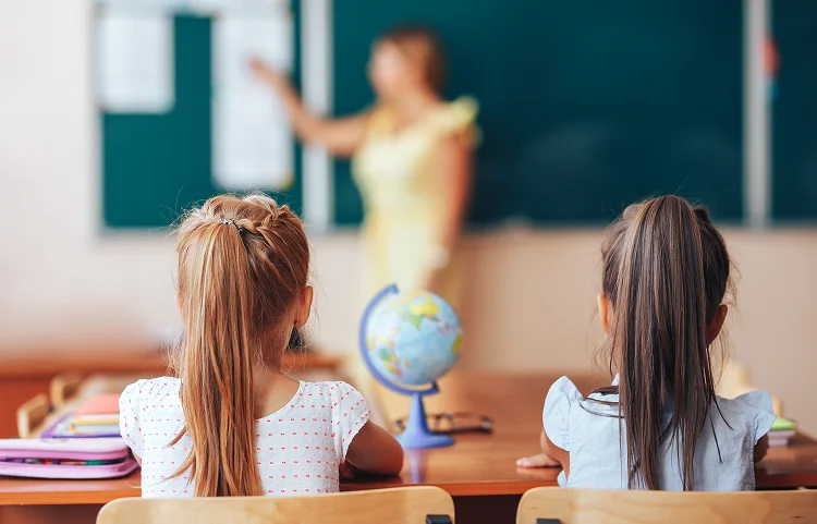 Children sat in class with globe on desk