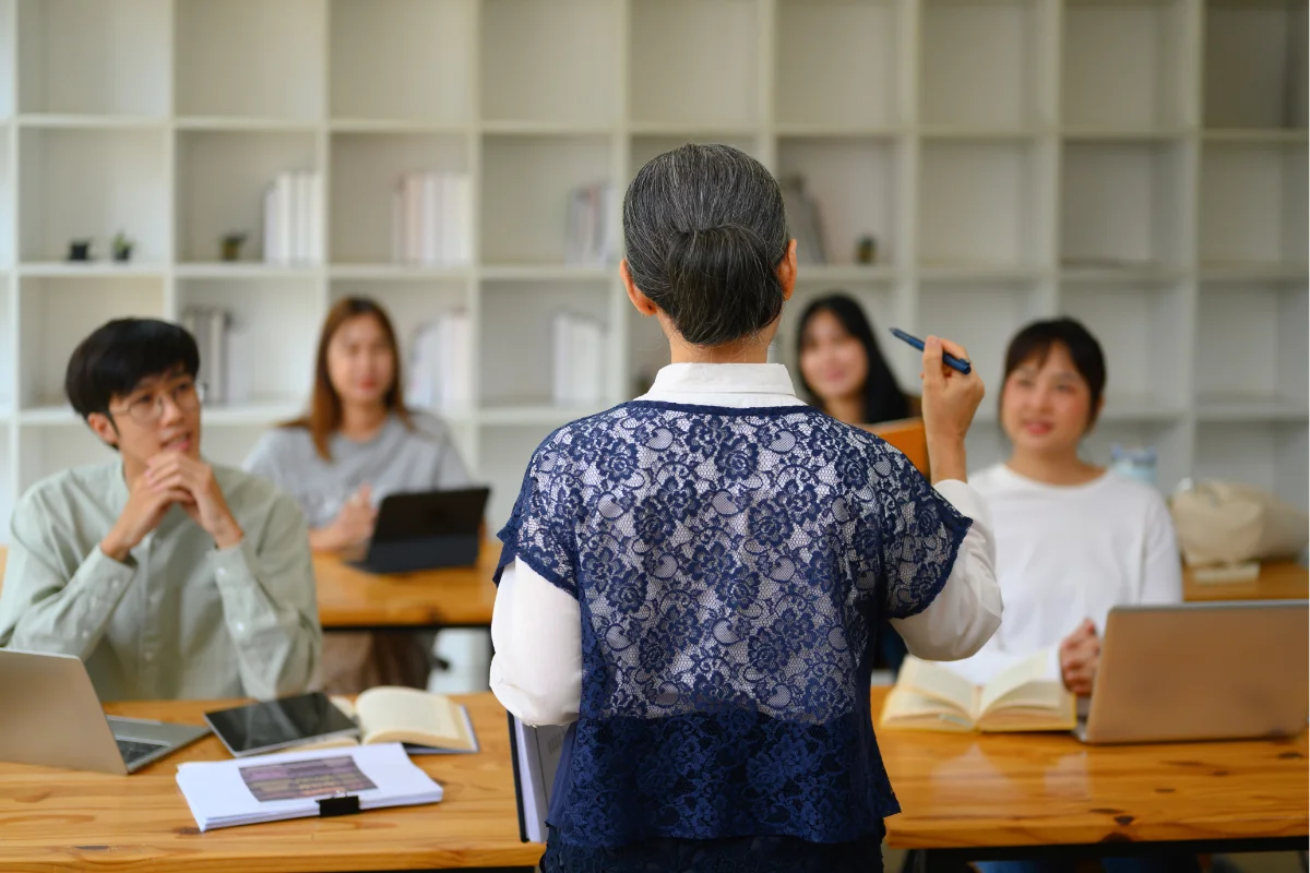 Senior professor talking to students during lecture in the classroom